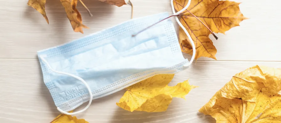 Medical mask with leaves on a desk